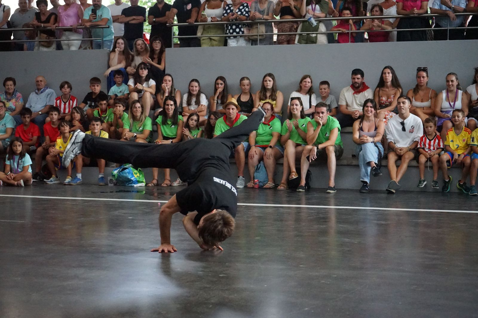 Bailarín de Space Breaking en pleno power move ante el público sentado en el show de Okondo