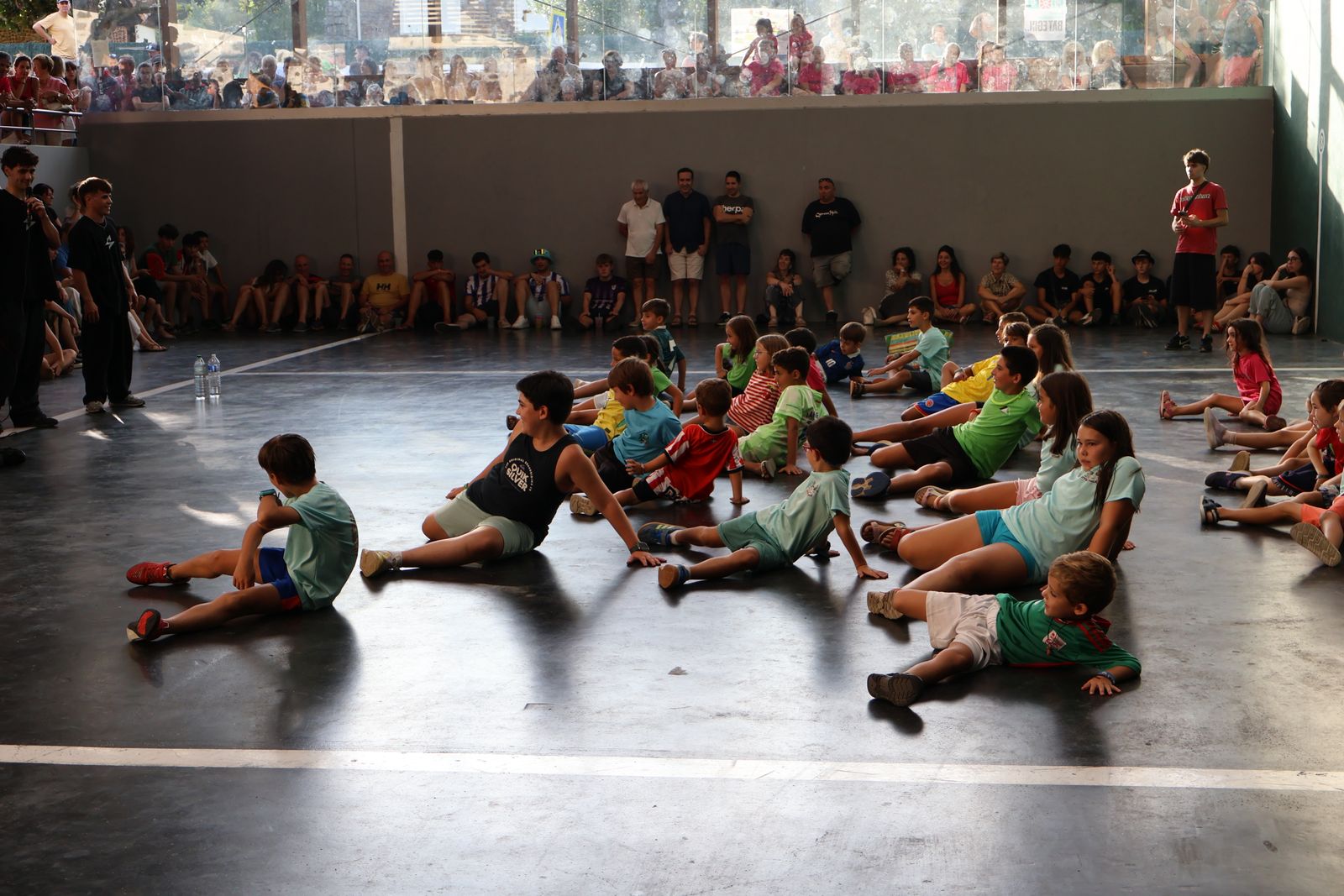 Grupo de niños haciendo un movimiento de breaking a la vez en el taller de Okondo