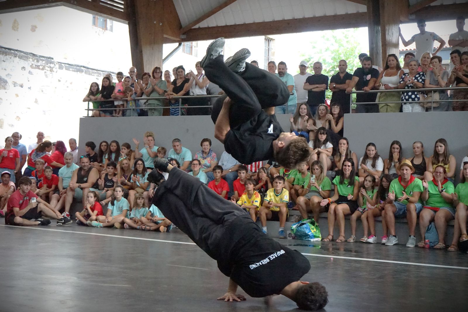Bailarín de Space Breaking haciendo un freeze en el suelo con público alrededor