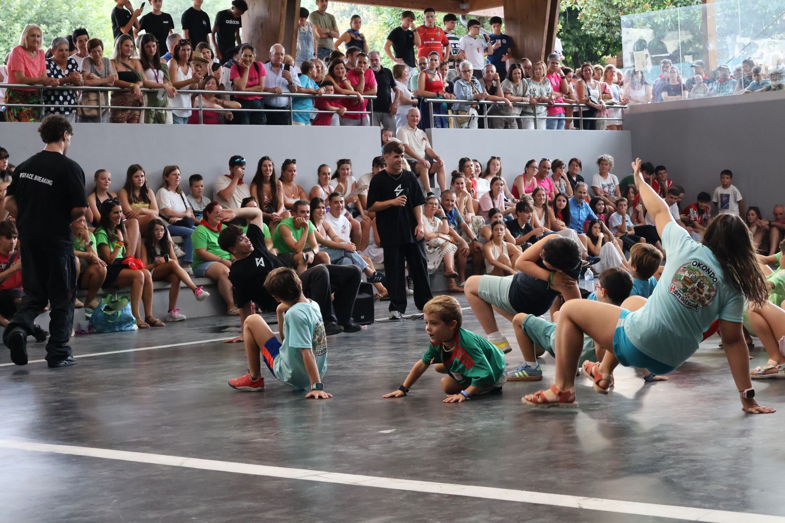 Grupo grande de niños haciendo breaking bajo un pórtico durante un taller de Space Breaking