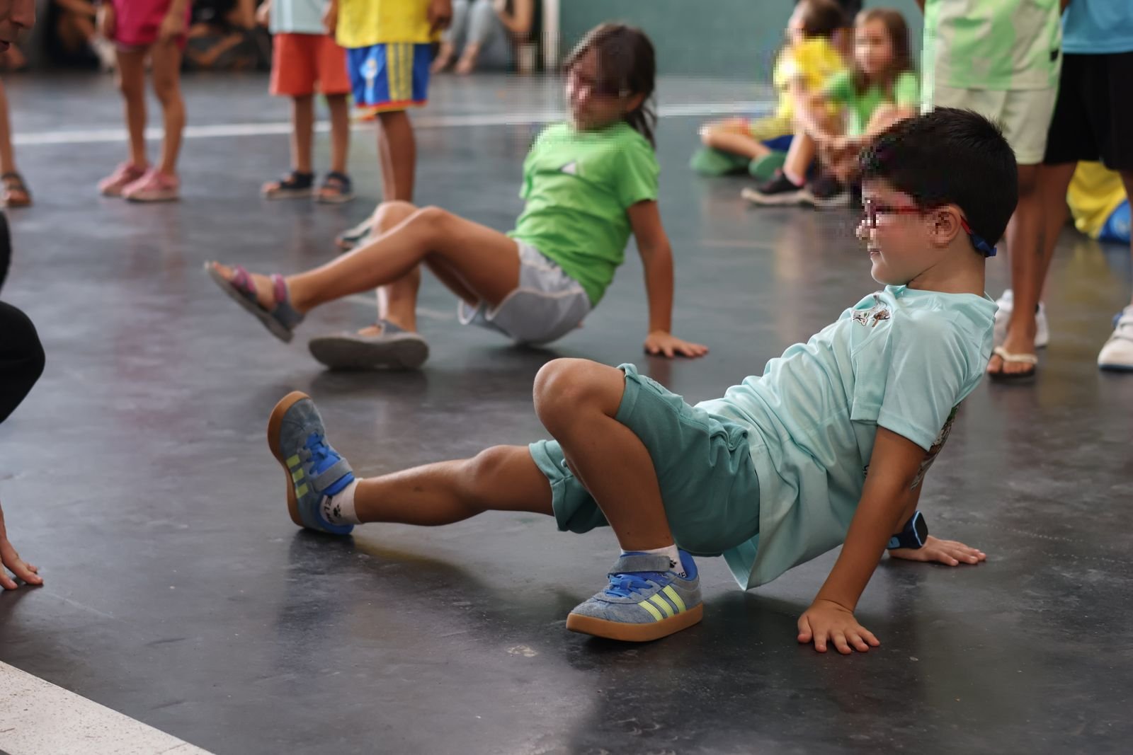 Dos niños practicando movimientos de suelo en un taller de Space Breaking